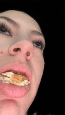 a close up of a person 's face with a piece of food in their mouth