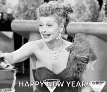 a black and white photo of a woman sitting at a table with a martini glass and the caption happy new year .