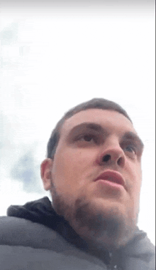 a close up of a man 's face with a beard looking at the camera .