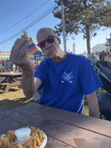 a man wearing a blue t-shirt that says east valley golf club on it