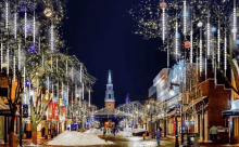 a city street with christmas lights hanging from trees