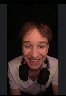 a young man wearing headphones and a white shirt is smiling