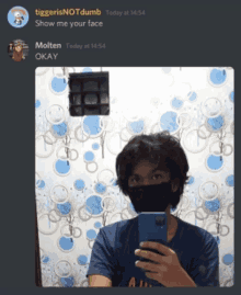 a man wearing a face mask is taking a picture of himself in a mirror