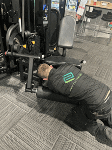 a man wearing a jacket that says upholstered is kneeling down in front of a machine