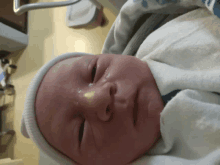 a newborn baby is laying in a hospital bed with his eyes closed