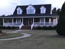 a large brick house with a large porch has a circle on the front door