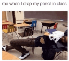 a man is laying on his stomach in a classroom with his pants down .