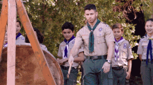 a group of boy scouts are standing in a line and one of them is wearing a uniform with the number 20 on it