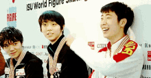 a group of young men are posing for a picture in front of a sign that says isu world figure skating