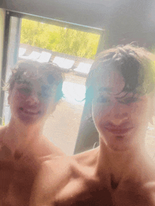 two boys are taking a selfie in front of a mirror