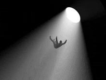 a silhouette of a person falling into a dark room