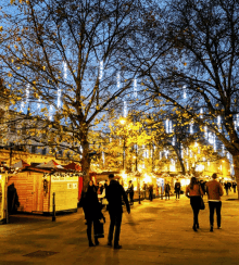 a group of people are walking down a street with a sign that says ' christmas ' on it