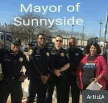 a group of police officers are posing for a picture with the mayor of sunnyside in the background .