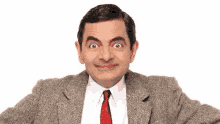 mr bean is wearing a suit and tie and making a face .