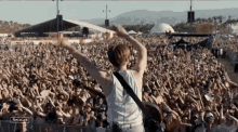 a man playing a guitar in front of a crowd at a music festival with the word coachella on the bottom