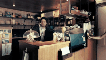 a man stands behind a counter in a kitchen with a sign that says ' i love you ' on it