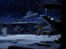 a man in a yellow suit is standing in the snow with a sword in his hand