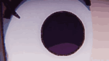 a close up of a bird house with a purple hole in it .