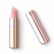 a pink lipstick is sitting on a white surface next to a gold tube .