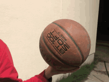 a person is holding a basketball that says tarmak on the side