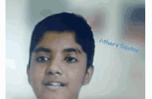 a close up of a young boy 's face with the name atharav written on the bottom .