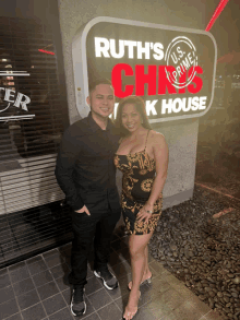 a man and woman pose in front of ruth 's chris steakhouse