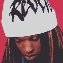 a man with dreadlocks is wearing a white beanie with the word roxy on it