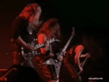 a group of people playing guitars in a dark room .