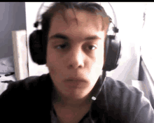 a young man wearing headphones has a green light on his head