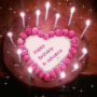 a heart shaped birthday cake with pink candles and the words happy birthday in advance