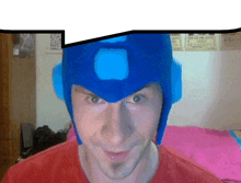 a man wearing a blue helmet with a square in the middle is smiling