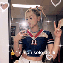 a girl taking a picture of herself in front of a mirror with the words " si son solo de illi " on the bottom