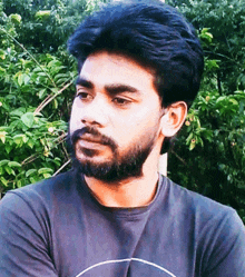 a man with a beard wearing a black shirt with a white circle on it