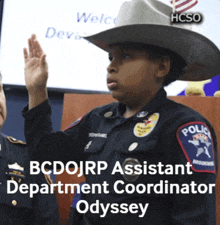 a young boy in a cowboy hat is being sworn in as a police assistant