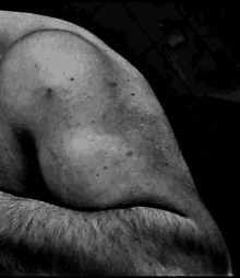 a black and white photo of a man 's arm and shoulder