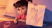 a cartoon girl is holding a drawing of a monster