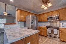 a kitchen with stainless steel appliances including a stove and refrigerator