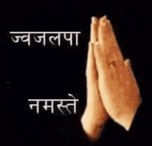 a close up of a person 's hands folded in prayer in a black background .