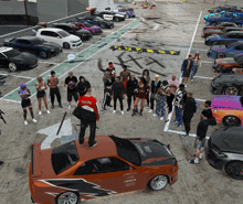 a group of people are standing around a car that says racing on the side