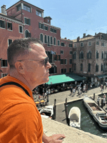 a man wearing sunglasses is looking out over a canal