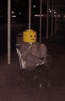 a man in a suit with a yellow lego head sits in a shopping cart