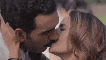 a man and a woman are kissing in a close up