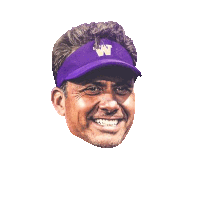 a man wearing a purple hat with the letter w on it is smiling