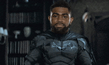 a man with a beard is wearing a batman suit