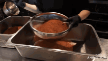 a person is sifting food into a stainless steel pan with the words made in animotica written on the bottom