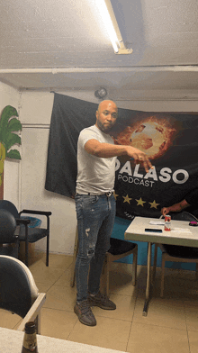 a man points at a palaso podcast banner