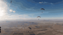 a group of parachutes are flying over the desert