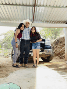 a man in a cowboy hat poses with two women