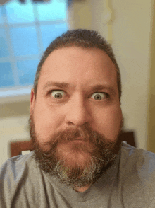 a man with a beard and mustache is making a surprised face