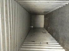 an empty shipping container with a gray floor